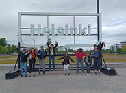 student group jumping in front of Helsinski sign photo of Finland group jumping in front of Helsinski sign